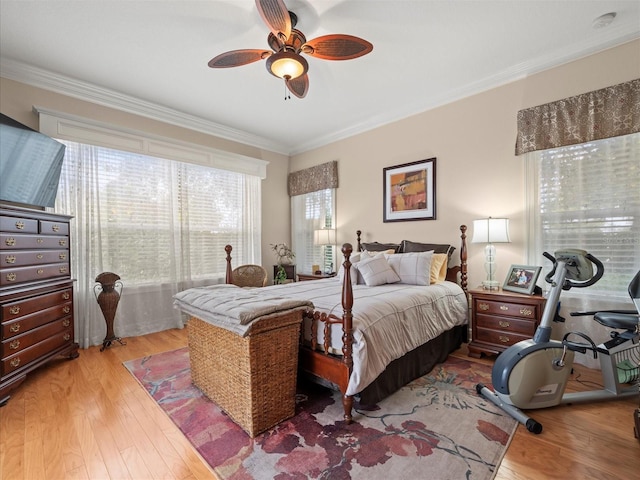 bedroom with ceiling fan, light wood-type flooring, and crown molding