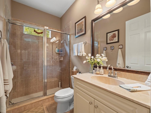 bathroom featuring tile patterned floors, vanity, toilet, and a shower with door