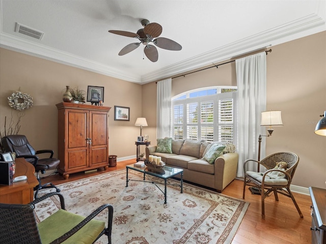 living room featuring light hardwood / wood-style floors, ceiling fan, and crown molding