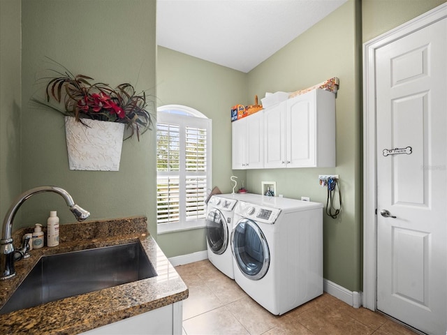 washroom featuring light tile patterned flooring, cabinets, sink, and washing machine and clothes dryer