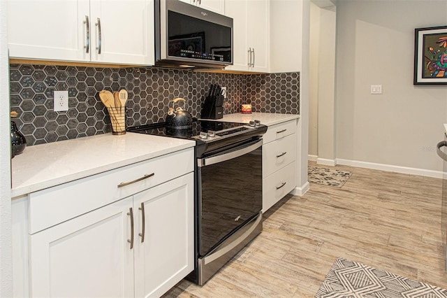 kitchen featuring decorative backsplash, white cabinetry, and appliances with stainless steel finishes