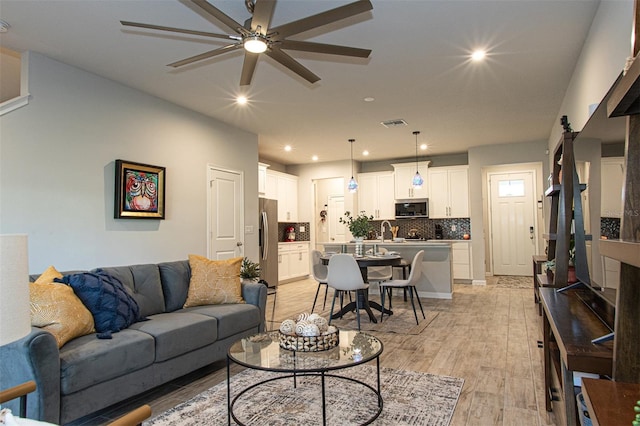 living room featuring ceiling fan and light wood-type flooring