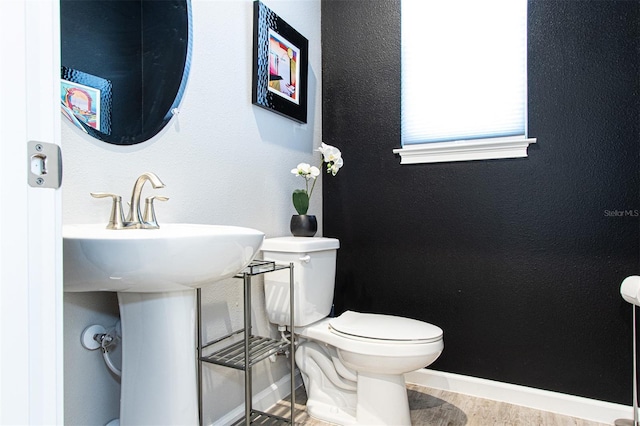 bathroom featuring hardwood / wood-style flooring and toilet