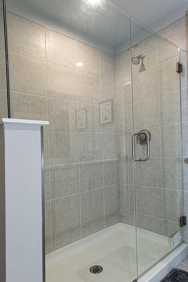 bathroom with a shower with door