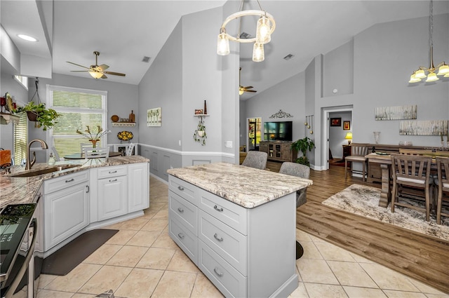 kitchen featuring light tile patterned flooring, a kitchen island, pendant lighting, and white cabinets