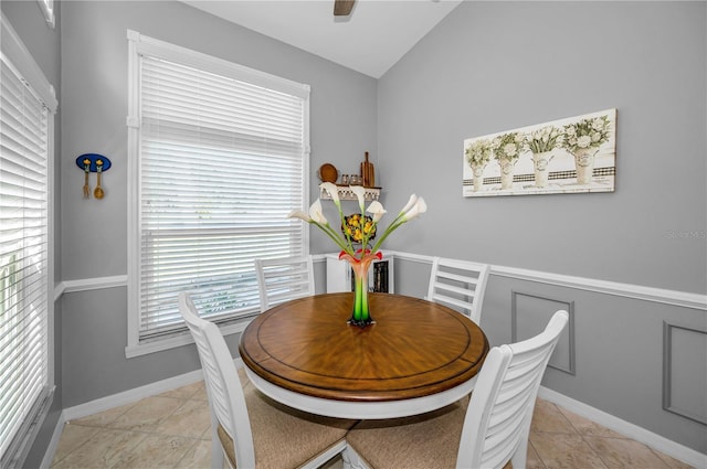 dining space with ceiling fan, lofted ceiling, and light tile patterned floors