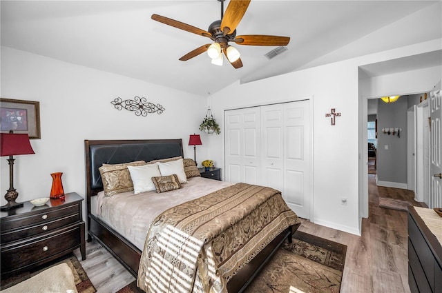 bedroom featuring vaulted ceiling, ceiling fan, light hardwood / wood-style floors, and a closet