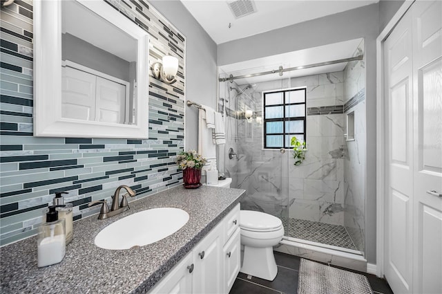 bathroom with tasteful backsplash, tile patterned flooring, vanity, an enclosed shower, and toilet