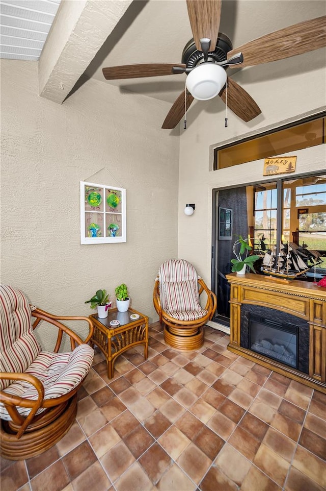 living area featuring ceiling fan and beam ceiling