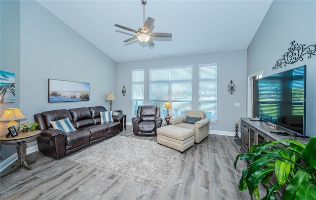 living room featuring ceiling fan, high vaulted ceiling, and light hardwood / wood-style flooring