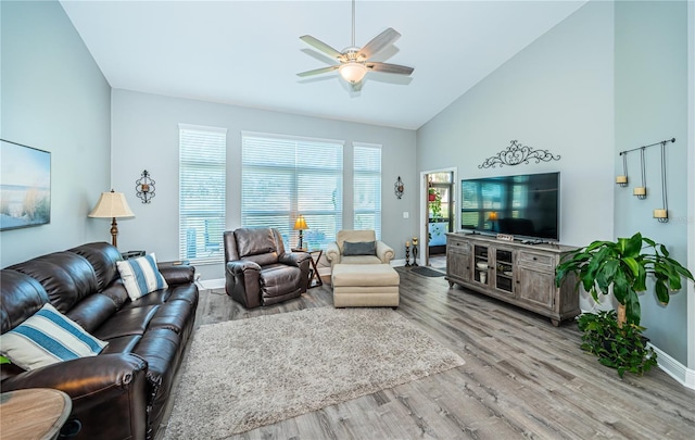 living room featuring ceiling fan, high vaulted ceiling, and light hardwood / wood-style flooring