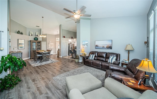 living room featuring wood-type flooring, high vaulted ceiling, and ceiling fan