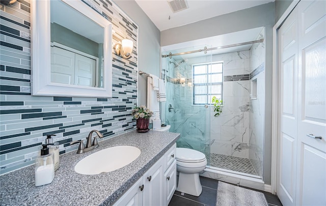 bathroom featuring tile walls, vanity, tasteful backsplash, a shower with shower door, and toilet