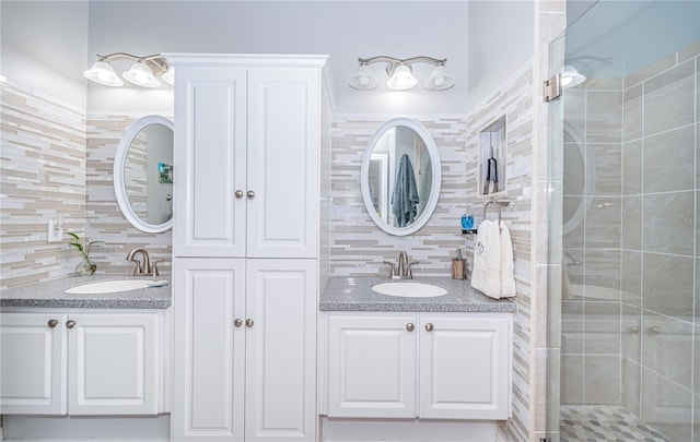 bathroom featuring tasteful backsplash, vanity, a shower with door, and tile walls