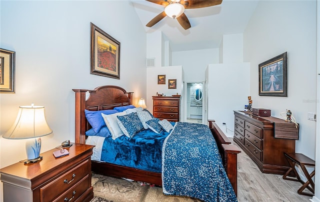 bedroom featuring ceiling fan, high vaulted ceiling, and light wood-type flooring