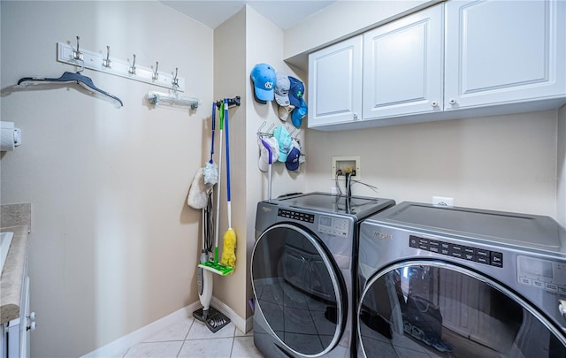 laundry area with cabinets, light tile patterned flooring, and washer and dryer