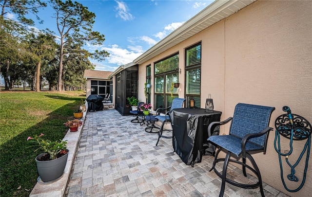 view of patio / terrace featuring grilling area and glass enclosure