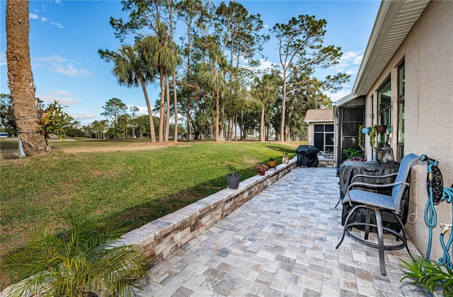 view of patio with grilling area and glass enclosure