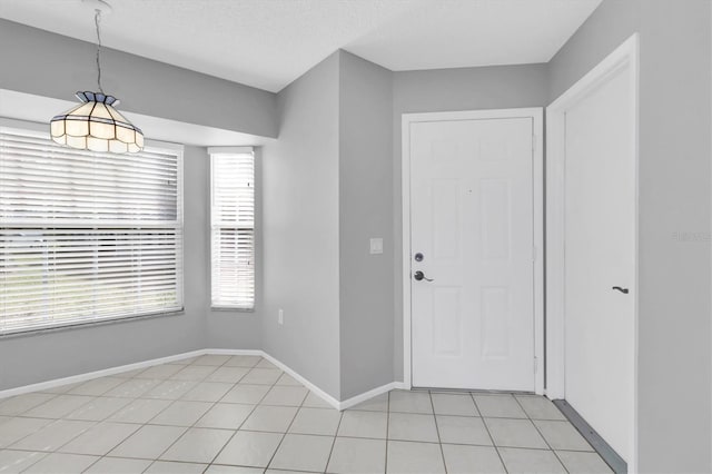 entrance foyer featuring a textured ceiling and light tile patterned flooring