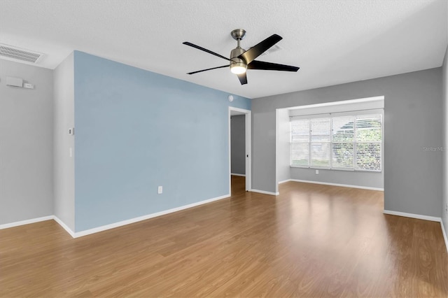 spare room featuring ceiling fan, wood-type flooring, and a textured ceiling