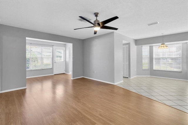 unfurnished living room featuring ceiling fan and light wood-type flooring