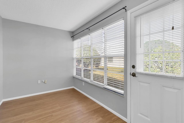 doorway with hardwood / wood-style floors and a textured ceiling