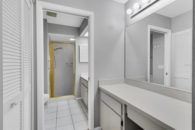 bathroom with tile patterned floors, toilet, vanity, and walk in shower