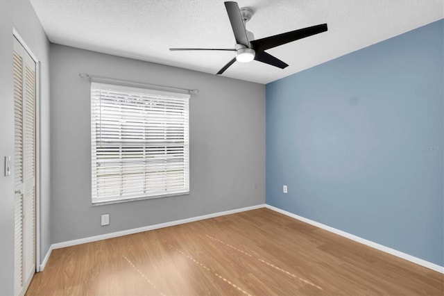 unfurnished bedroom with multiple windows, ceiling fan, and a closet