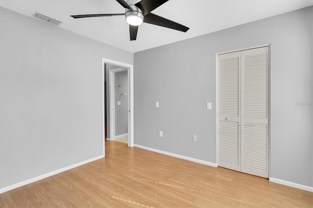 unfurnished bedroom with light wood-type flooring, a closet, and ceiling fan