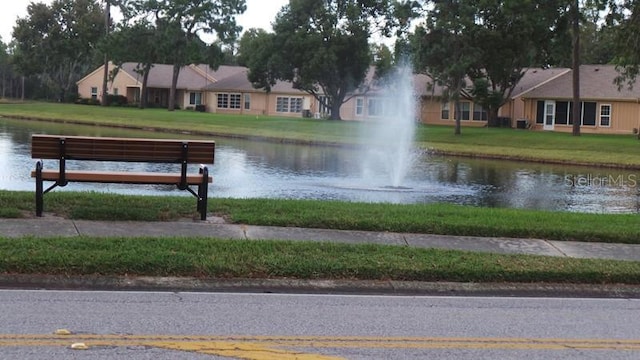 view of community with a lawn and a water view