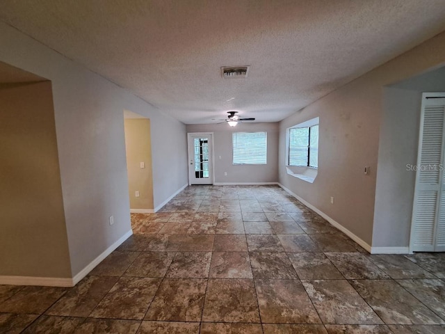 empty room featuring ceiling fan and a textured ceiling