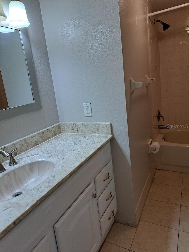 bathroom featuring tile patterned flooring, vanity, and tiled shower / bath combo