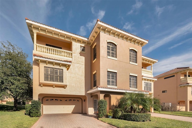 mediterranean / spanish house with a balcony, a garage, and a front lawn