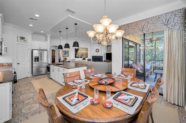 dining space featuring an inviting chandelier, crown molding, and sink