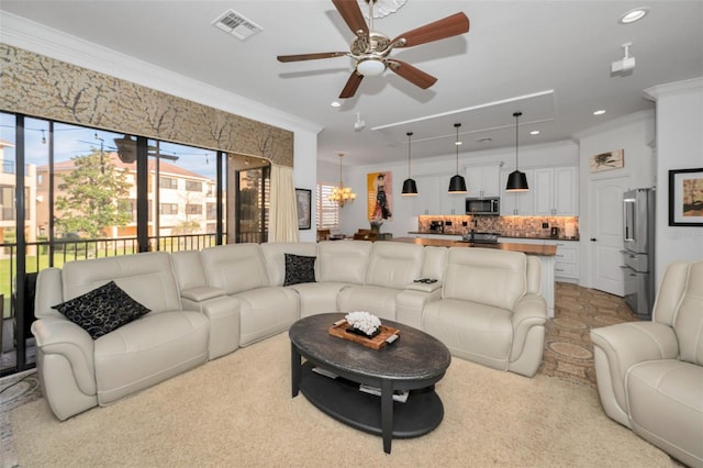 living room with ceiling fan with notable chandelier and ornamental molding