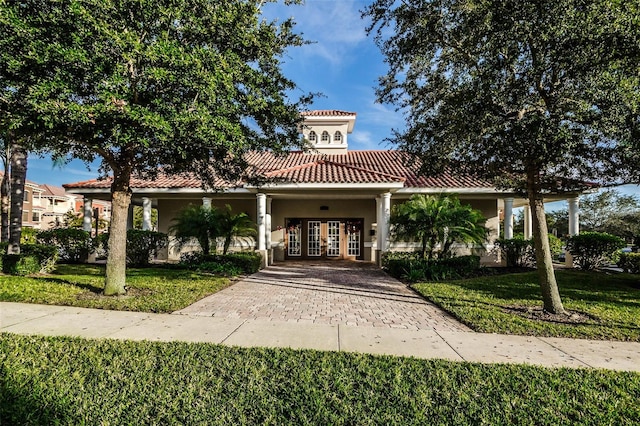 mediterranean / spanish house with french doors and a front lawn