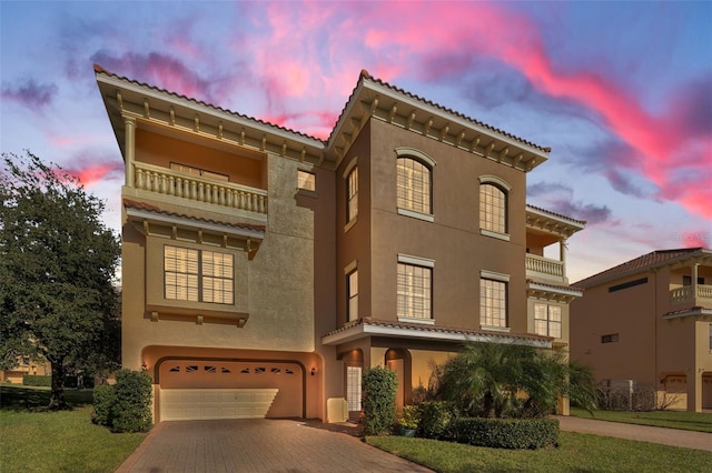 mediterranean / spanish-style house with a yard, a balcony, and a garage