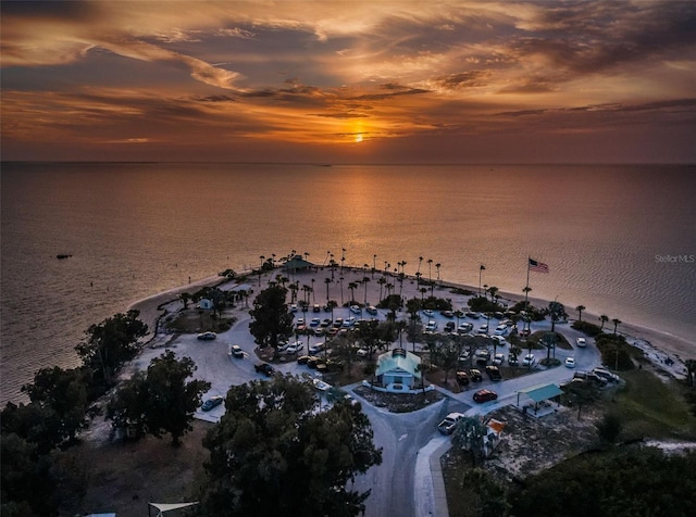 aerial view at dusk featuring a water view