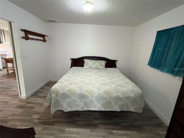 bedroom featuring dark hardwood / wood-style floors and a textured ceiling