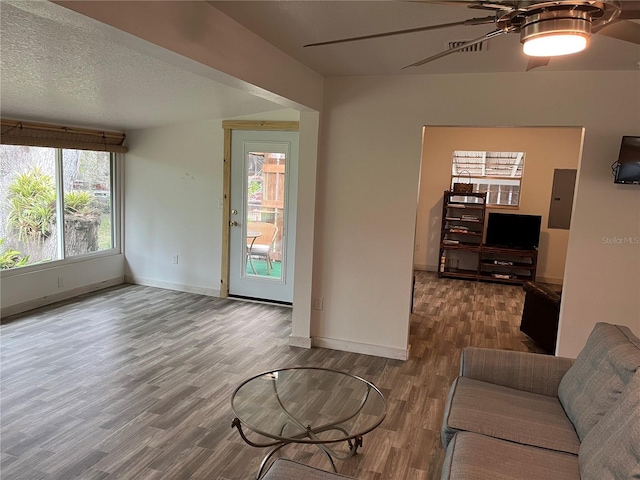 living room with electric panel, ceiling fan, and hardwood / wood-style floors