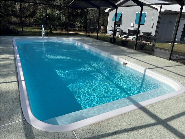 view of pool featuring glass enclosure