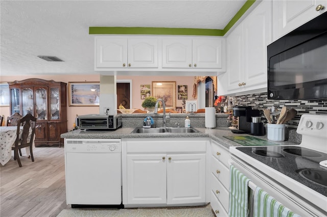 kitchen featuring white cabinets, backsplash, white appliances, and sink