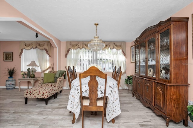 dining area with a textured ceiling and an inviting chandelier