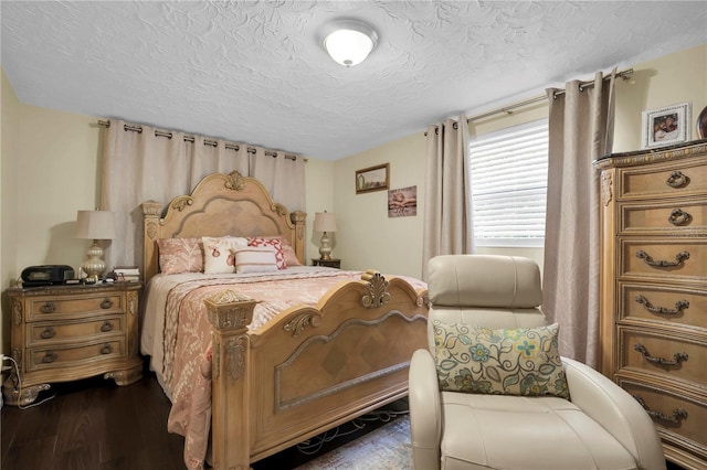 bedroom featuring a textured ceiling and dark wood-type flooring