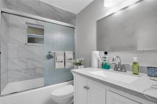 full bathroom with vanity, bath / shower combo with glass door, and toilet