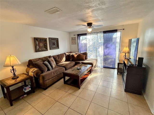 tiled living room featuring ceiling fan and a textured ceiling