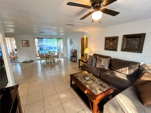 living room with a wealth of natural light, light tile patterned floors, and ceiling fan