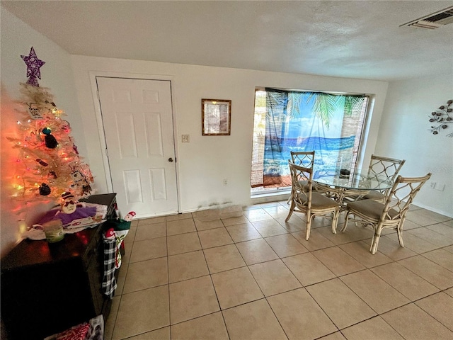 tiled dining area with a textured ceiling