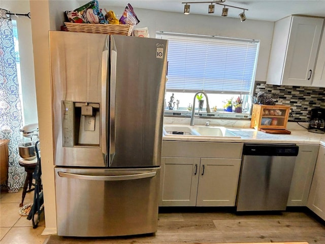 kitchen featuring backsplash, sink, white cabinetry, and stainless steel appliances