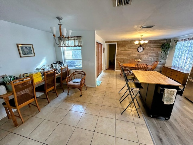 tiled dining room with a notable chandelier